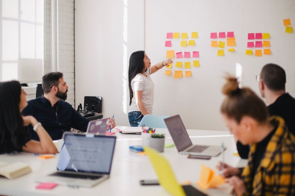Marketing team reviewing campaign performance on a laptop in a bright office